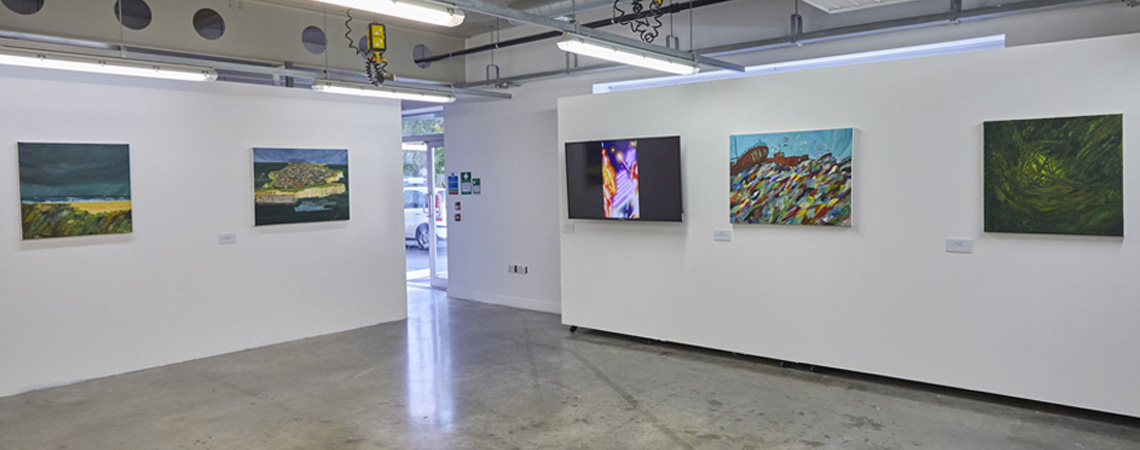 An exhibition of student work by Mark Chamberlain including paintings and an artwork on a screen