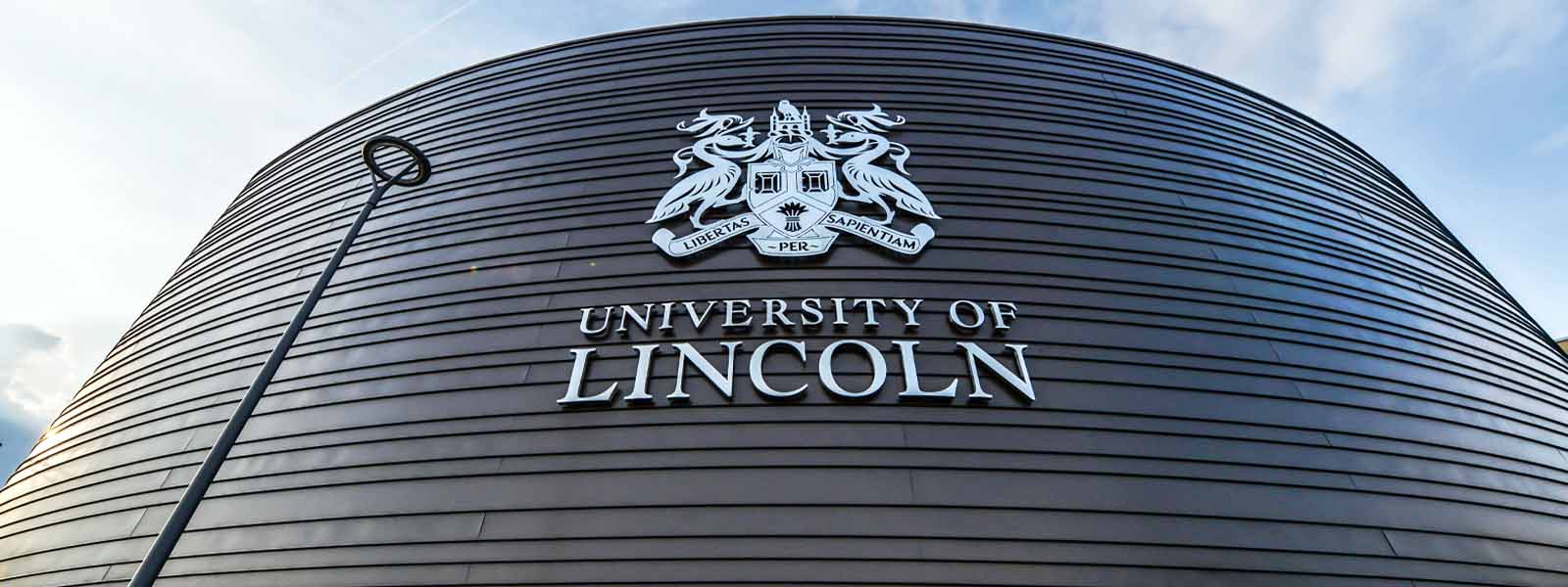 The University of Lincoln crest and logo on the side of a building
