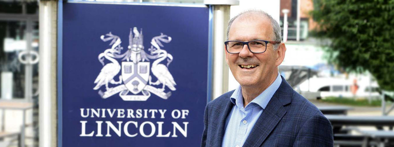 The Vice Chancellor stood next the University of Lincoln crest