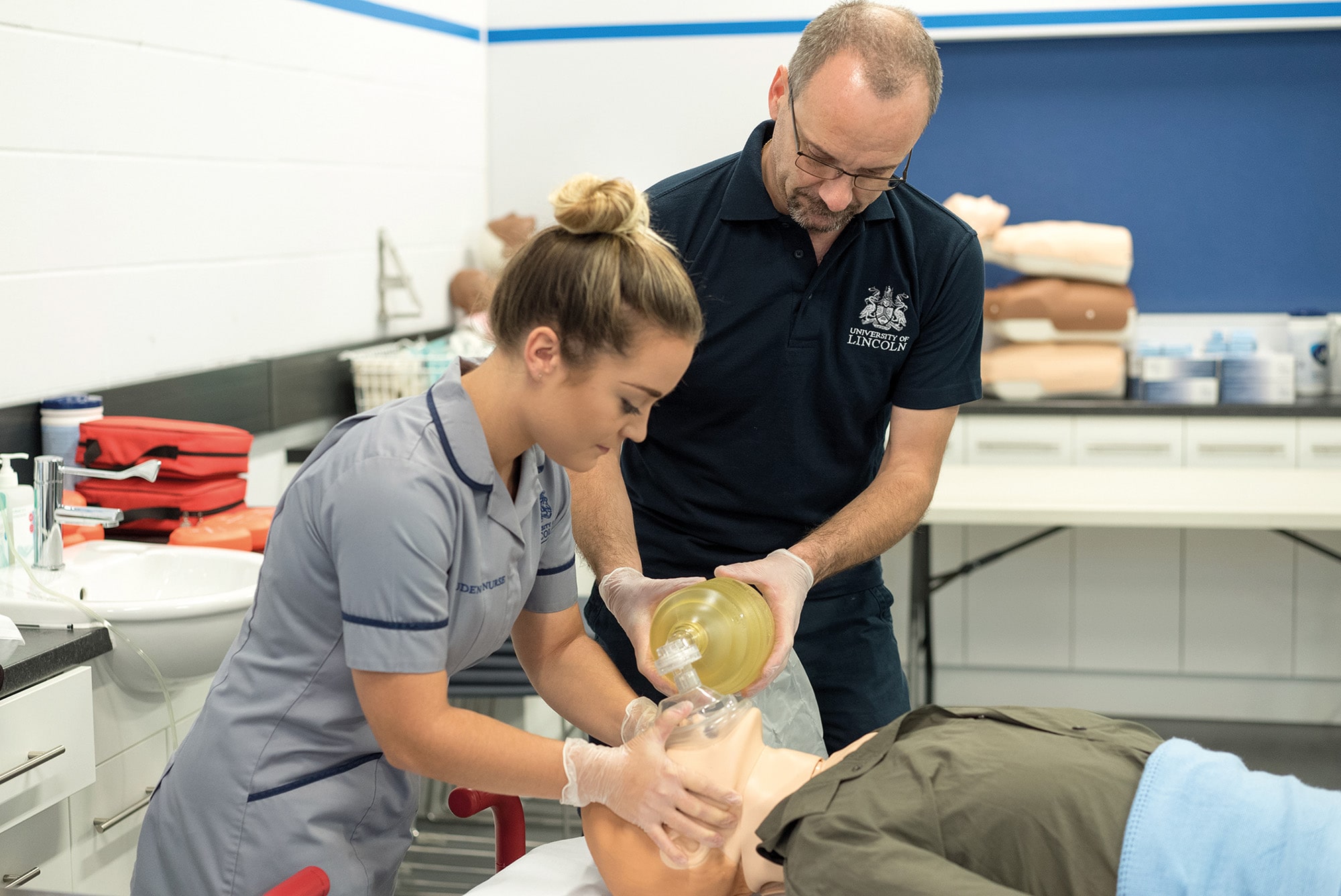 A student nurse practice using a manual resuscitation pump.
