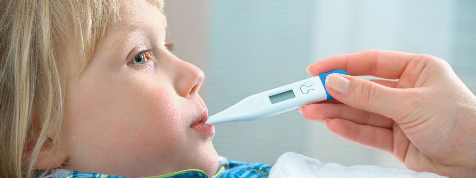 A young child with a thermometer placed in their mouth