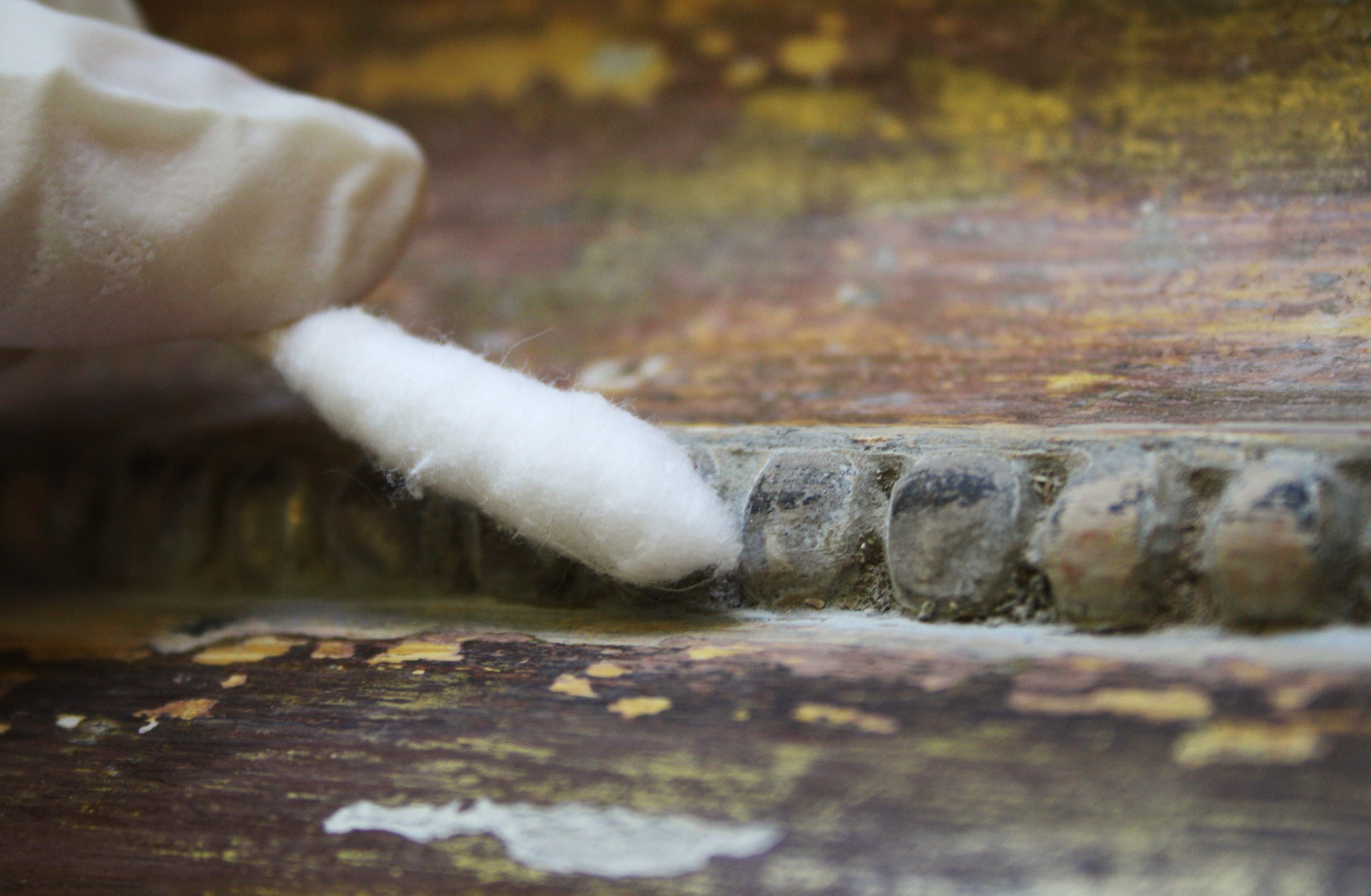 A cotton swab cleaning a decorative surface