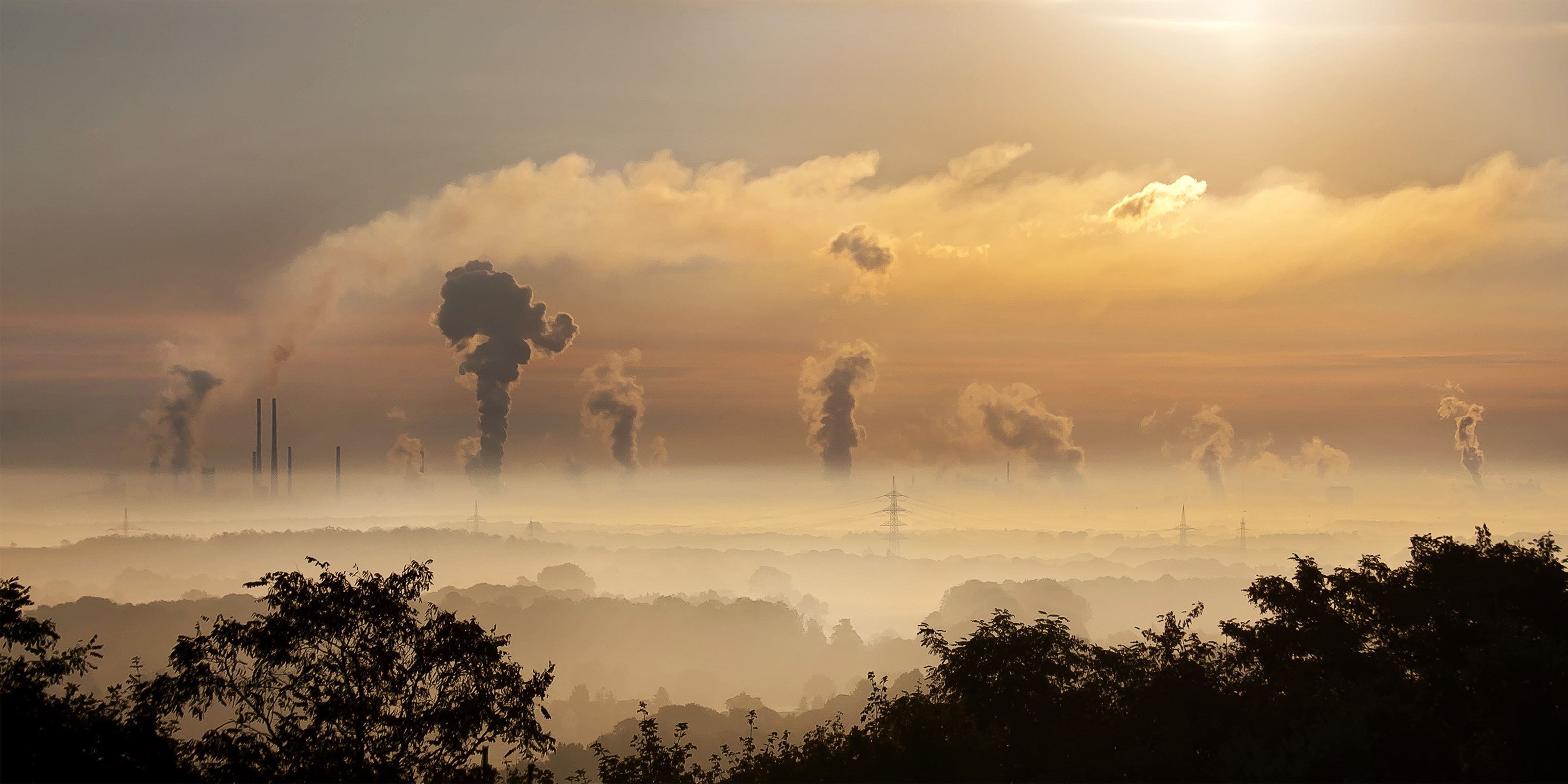 Factory chimneys with smoke and steam rising into the air