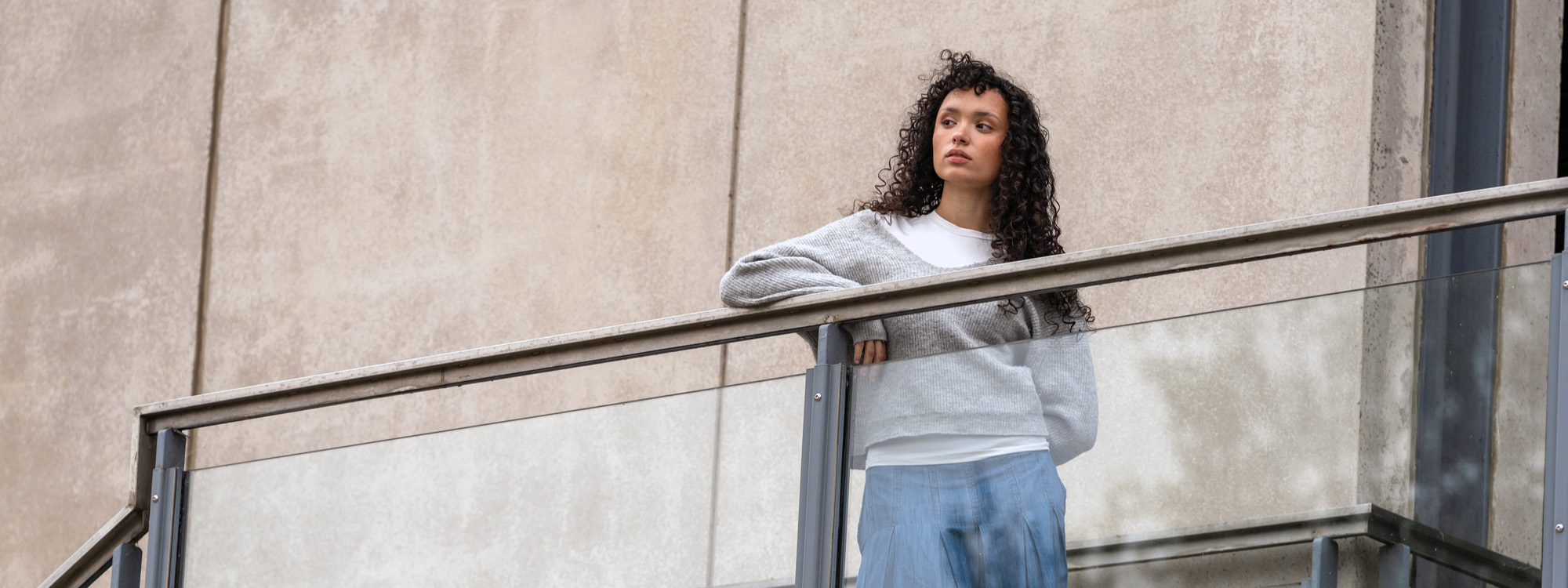 A student standing on a balcony looking into the distance