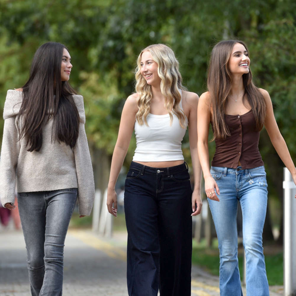 Students walking on campus by trees