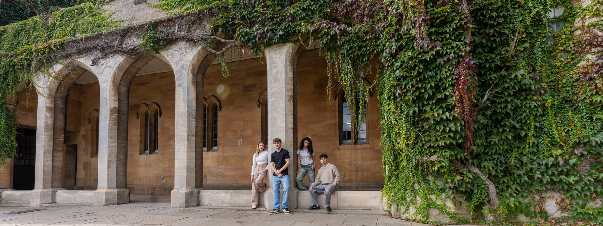 A group of students posing in front of an old building