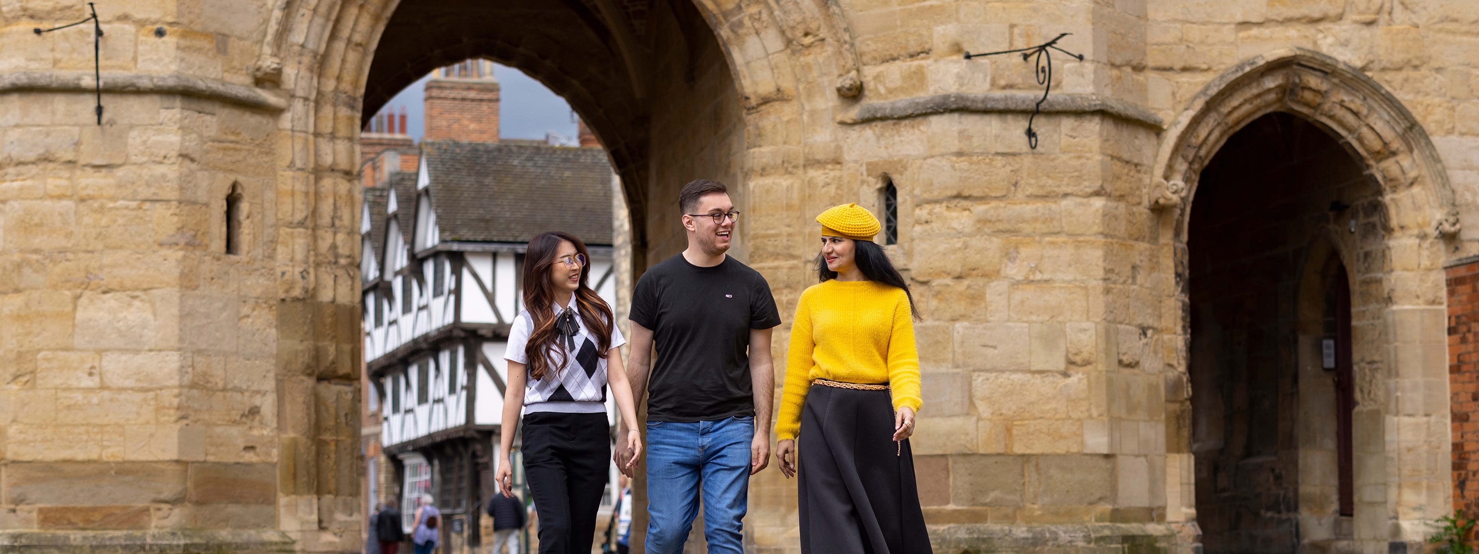 Students walking through stone archway