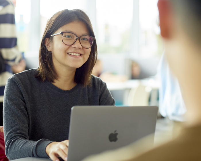 A student looks up from their laptop