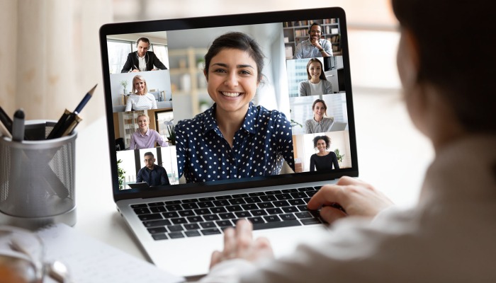 A person watching a video conference on a laptop screen