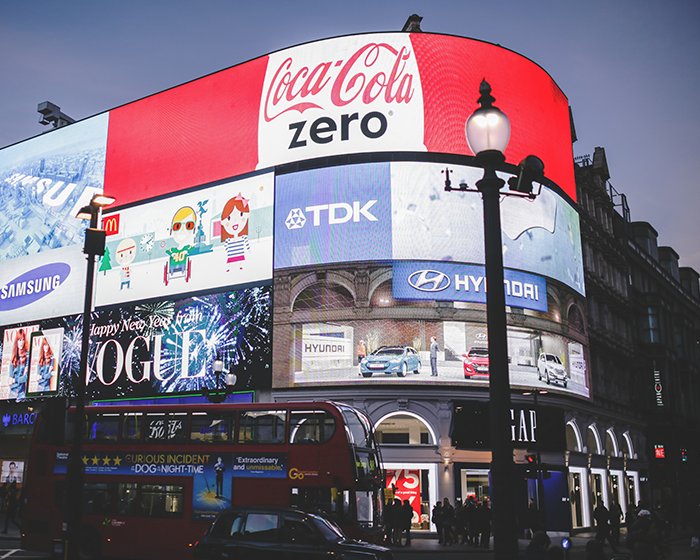 A large screen on the side of a building displaying advertisements