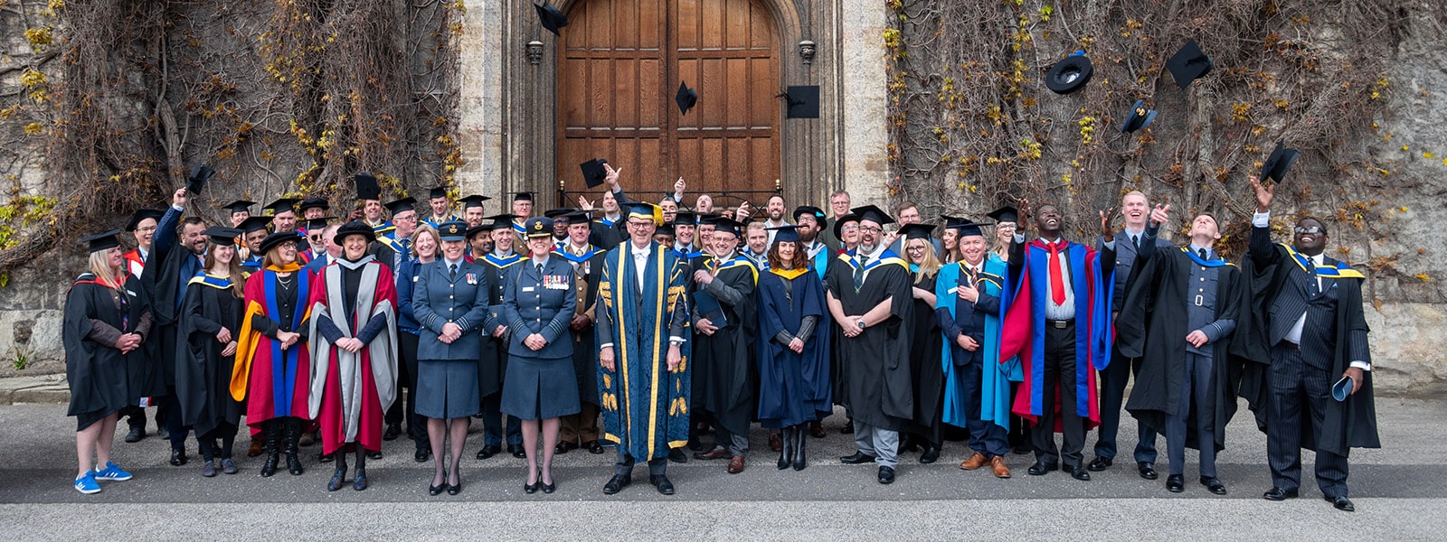 A group of Work-Based and Diverse graduates standing for a photo in front of Lincoln Crown Court