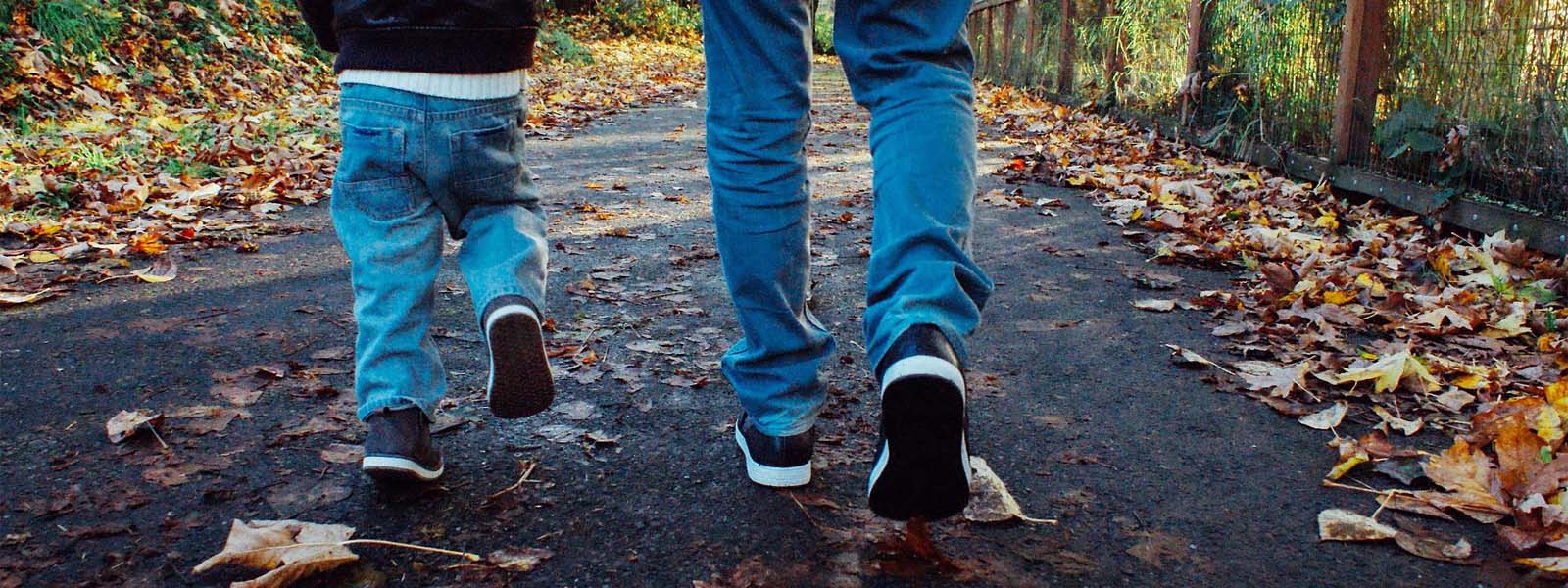 A father walking with a child along a pathway