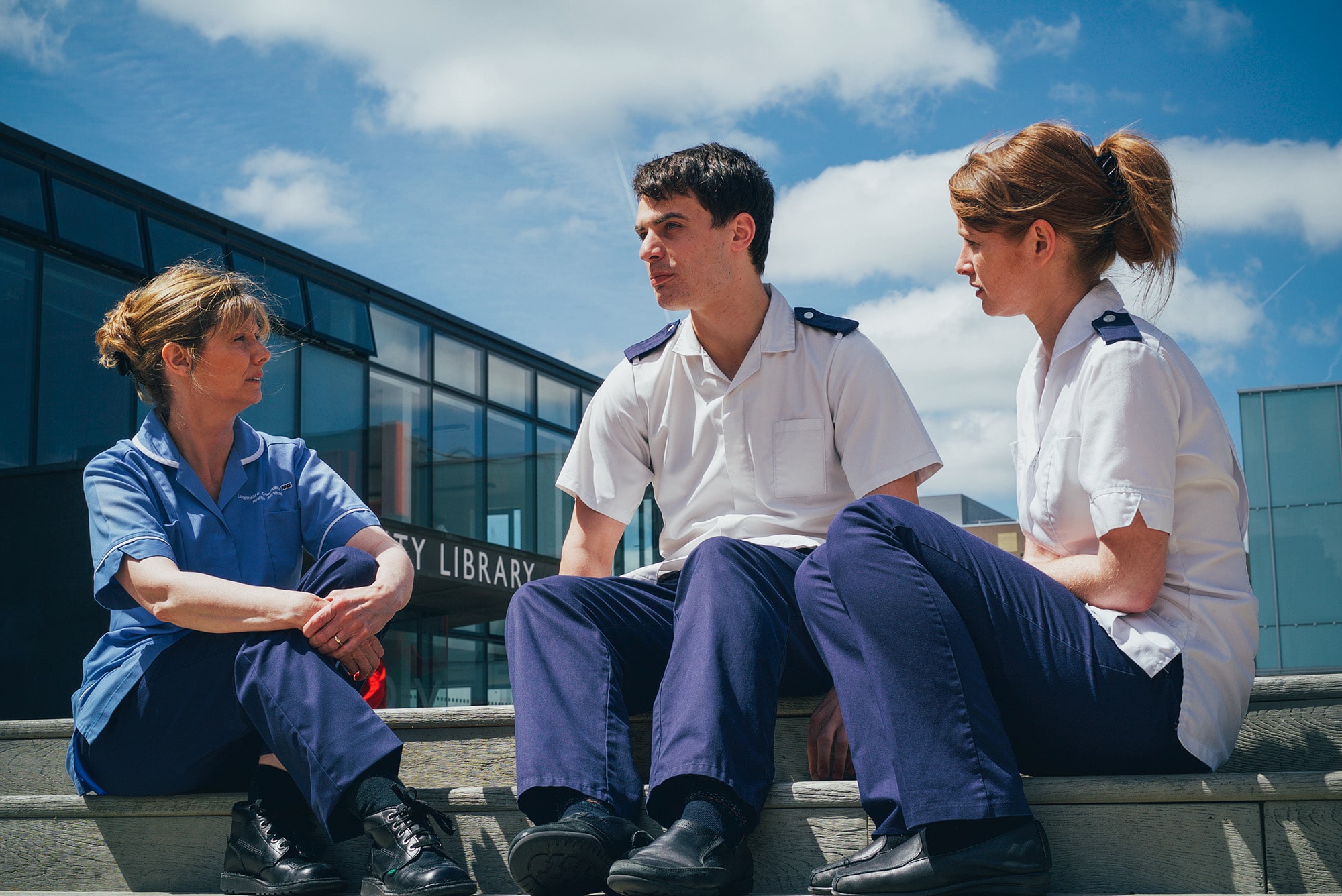 Three nurses sat outside